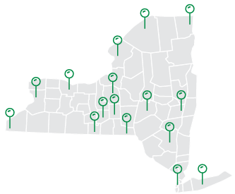 Graphic illustration of the state of NY, sectioned by county. The state is light grey with outlined counties in white with medium green pins marking locations throughout.