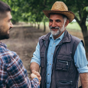 Farmer shaking the hand of another farmer in a field